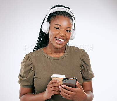 Buy stock photo Portrait, music and coffee with a black woman in studio on a gray background listening to the radio. Phone, social media or headphones and a young female streaming an audio playlist with a drink