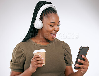 Buy stock photo Music, coffee and surprise with a black woman in studio on a gray background listening to the radio. Phone, social media or headphones and a young female streaming an audio playlist with a drink