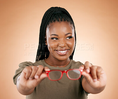 Buy stock photo Glasses, black woman and frame choice of a happy young person hands holding frames in a studio. Brown background, isolated and happiness of a female thinking about lens vision and eye healthcare