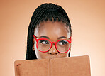 Black woman, notebook and hide face in studio for thinking, glasses or planning schedule for small business online. Young african entrepreneur, book or ideas for goal, vision or notes by background