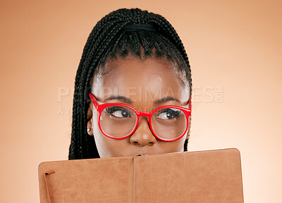 Buy stock photo Black woman, notebook and hide face in studio for thinking, glasses or planning schedule for small business online. Young african entrepreneur, book or ideas for goal, vision or notes by background