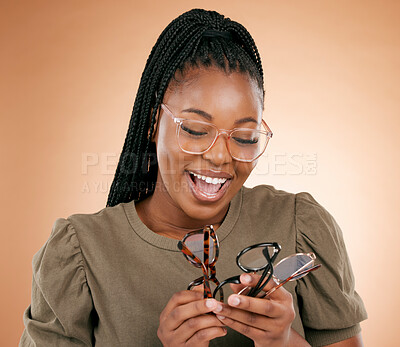 Buy stock photo Optometry, choice and woman with glasses in studio choosing a new frame for her prescription lens. Eyewear, happy and African female with spectacles for optical health isolated by brown background.