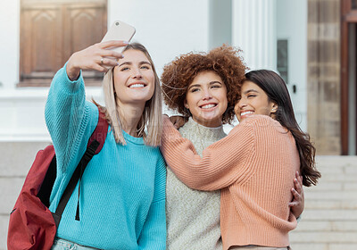Buy stock photo Women students, selfie and smile with hug at college campus for goals, diversity and social network. Gen z woman, group and smartphone with embrace, happiness and studying at university for success
