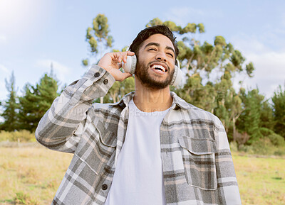 Buy stock photo Music, happy and man relax in a park, smile and laughing at podcast or audio track against nature background. Earphones, laugh and handsome guy listening to online comedy, song or playlist in forest