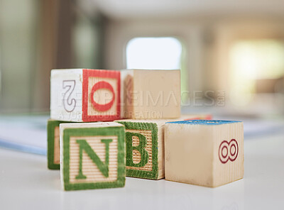 Buy stock photo Wooden blocks, table and letters for learning, education or childhood development at home. Colorful wood cube toys to learn numbers or alphabet for back to school, spelling or mathematics to read