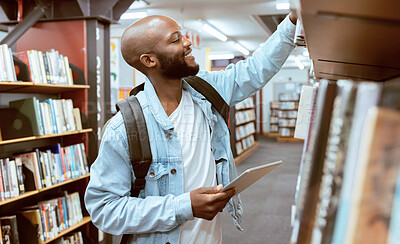 Buy stock photo Black man, student and library bookshelf  of a university, college and knowledge center. Notebook, happy young person and smile of a male with books for learning and study research info at school 