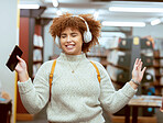 Music, dance and headphones with a student black woman listening to the radio in a university library. Phone, internet and a young female college pupil streaming audio while dancing or having fun