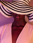 Fashion, beauty and woman in neon light, UV and purple studio background wearing a sun hat. Style, makeup and African American female model with dark skin aesthetic creativity, color and design