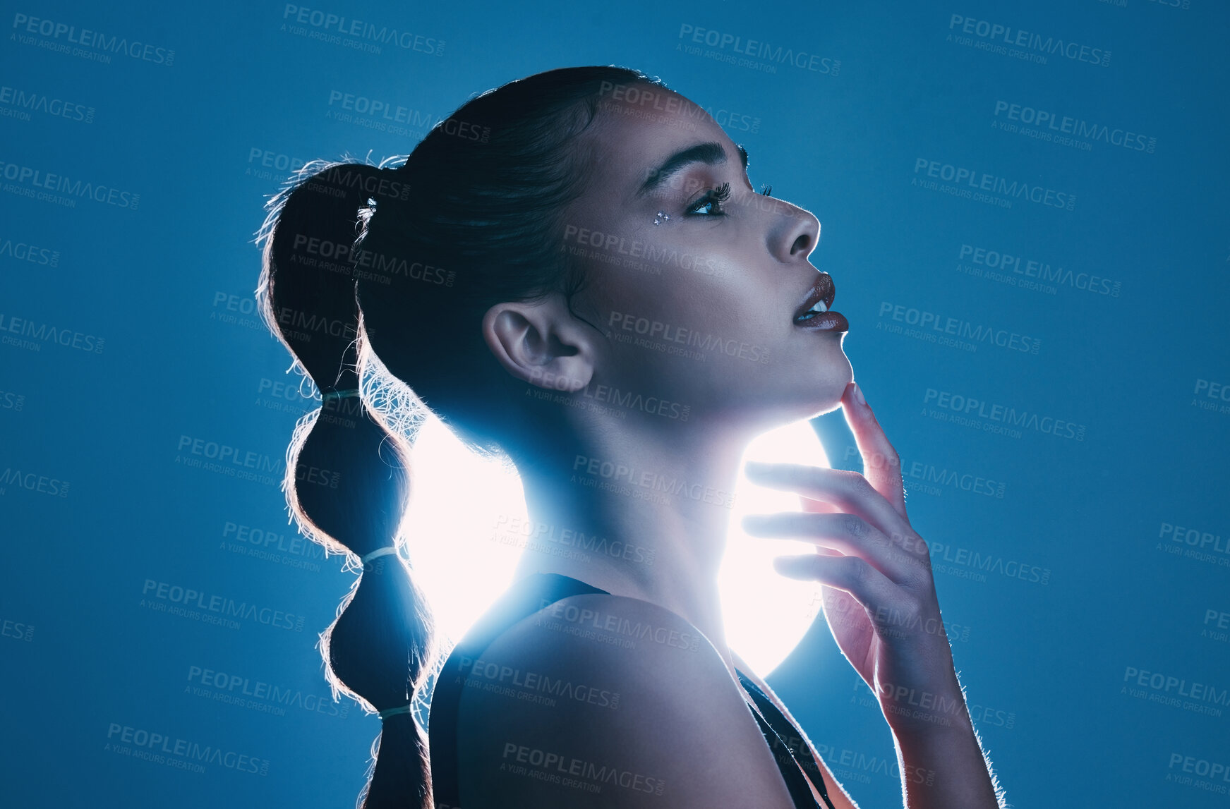 Buy stock photo Woman, beauty and profile of a model thinking in a studio with cosmetics and makeup. Young person, face hand touch and zen female with lighting and blue background isolated feeling relax and calm