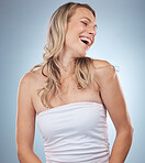 Beauty, skincare and laugh with a model woman in studio on a gray background enjoying a joke or humor. Facial, cosmetics and funny with an attractive young female laughing for natural treatment