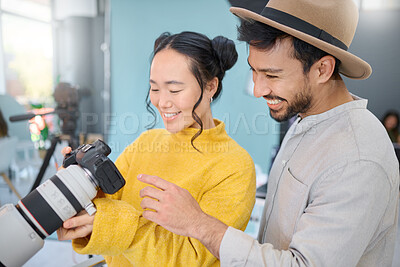 Buy stock photo Creative, photography and photographer talking to a model while looking at pictures on a camera. Discussion, photoshoot and young cameraman choosing a image with a woman in a creative artistic studio
