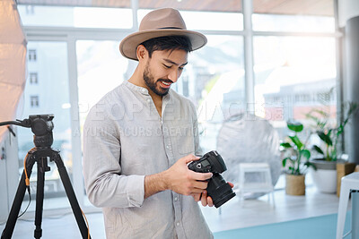 Buy stock photo Photographer, camera and man in studio for catalog, selection and photo, happy and photo shoot. Backstage, photography and professional asian male choosing picture for fashion, magazine and creative 