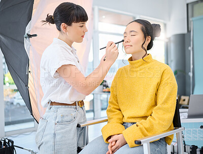 Buy stock photo Beauty, makeup artist and model doing makeup on a for a creative photoshoot in a studio. Cosmetics, art and beautician preparing a young Asian woman with a cosmetic routine for a photography job.
