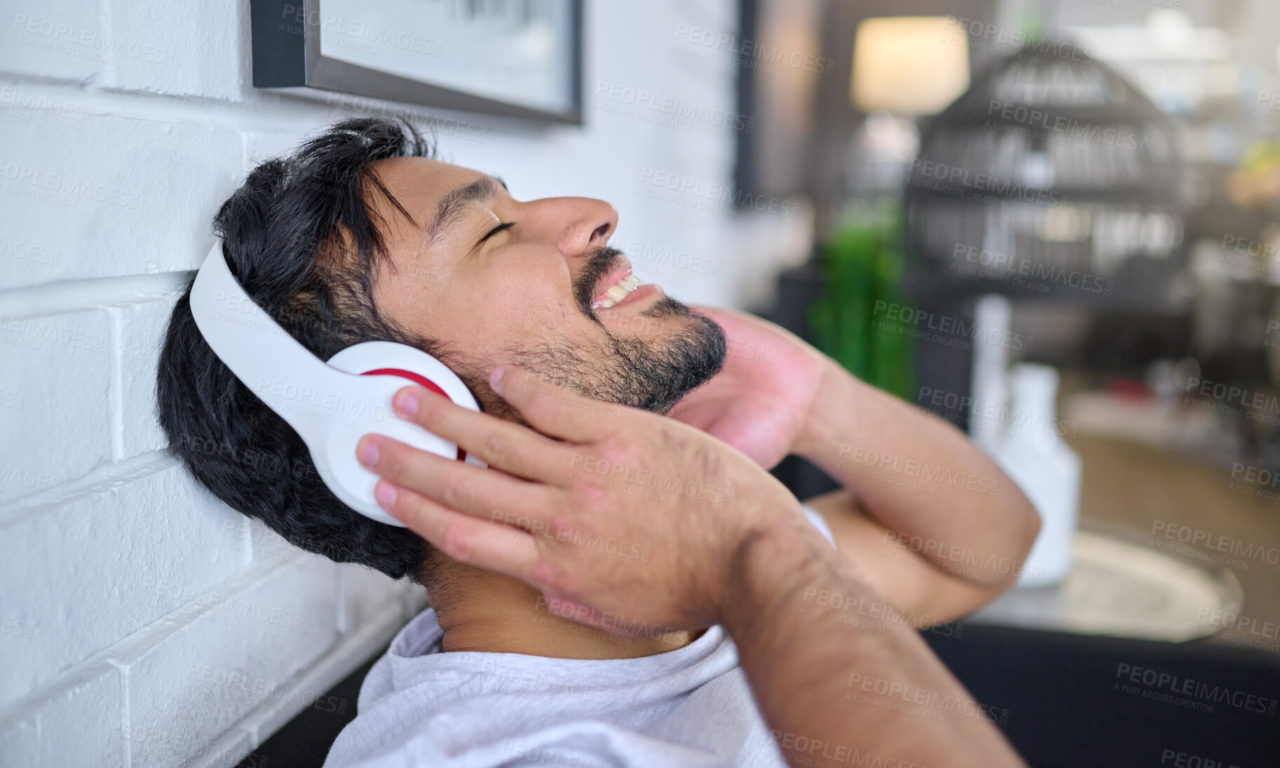 Buy stock photo Relax, music and man with headphones in home living room streaming radio or podcast. Freedom, technology and face of happy male in lounge listening to relaxing song, audio track or album in house.