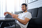 Phone, music and man with headphones in home living room streaming radio or podcast. Cellphone, technology and male in lounge sitting on floor listening to song, audio or album on mobile smartphone.
