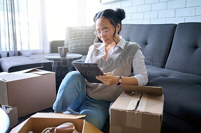 Buy stock photo Real estate, tablet and Asian woman moving into new home while planning or calculating mortgage online. Relocation boxes, technology and female property owner or remote worker in living room of house