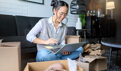 Buy stock photo Real estate, laptop and Asian woman moving into new home while planning or calculating mortgage online. Relocation boxes, computer and female property owner or remote worker in living room of house.