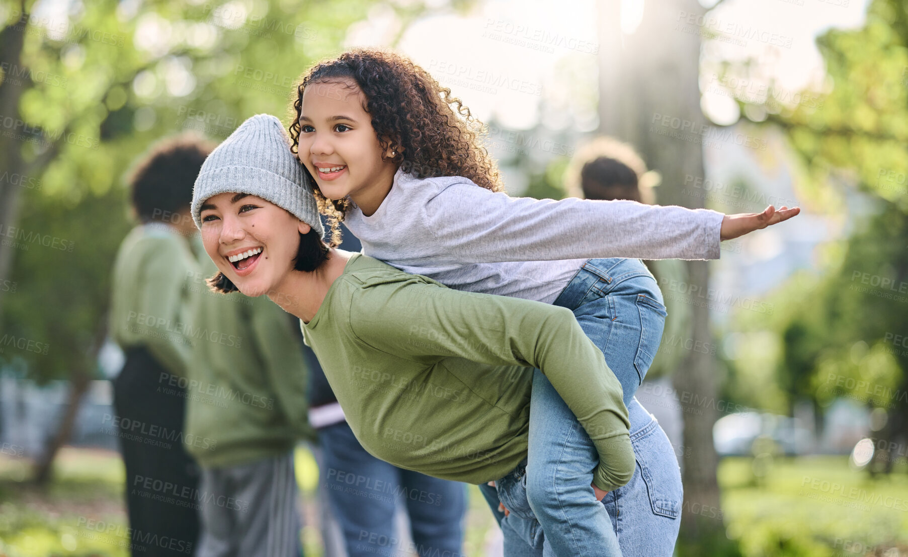 Buy stock photo Mother, piggy back and interracial family fun of a girl and mom together in nature. Park, happy summer and mama with love and care for child playing outdoor in a garden with blurred background