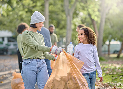 Buy stock photo Volunteer, child and woman cleaning plastic in park with garbage bag for a clean environment. People learning and helping with trash for eco friendly, community service and recycling bottle in nature