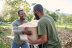 Black man, charity and holding box in park of donation, community service or social responsibility. Happy guy, NGO workers and team helping with package for volunteering, support and society outreach