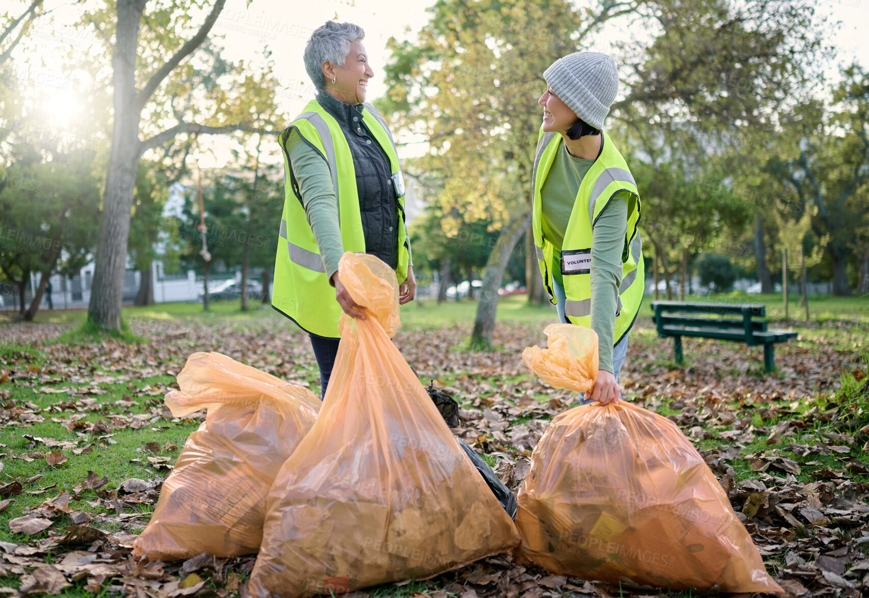 Buy stock photo Volunteer women, community service and cleaning park with garbage bag for a clean environment. Team talking and helping with trash for eco friendly lifestyle and recycling project outdoor in nature