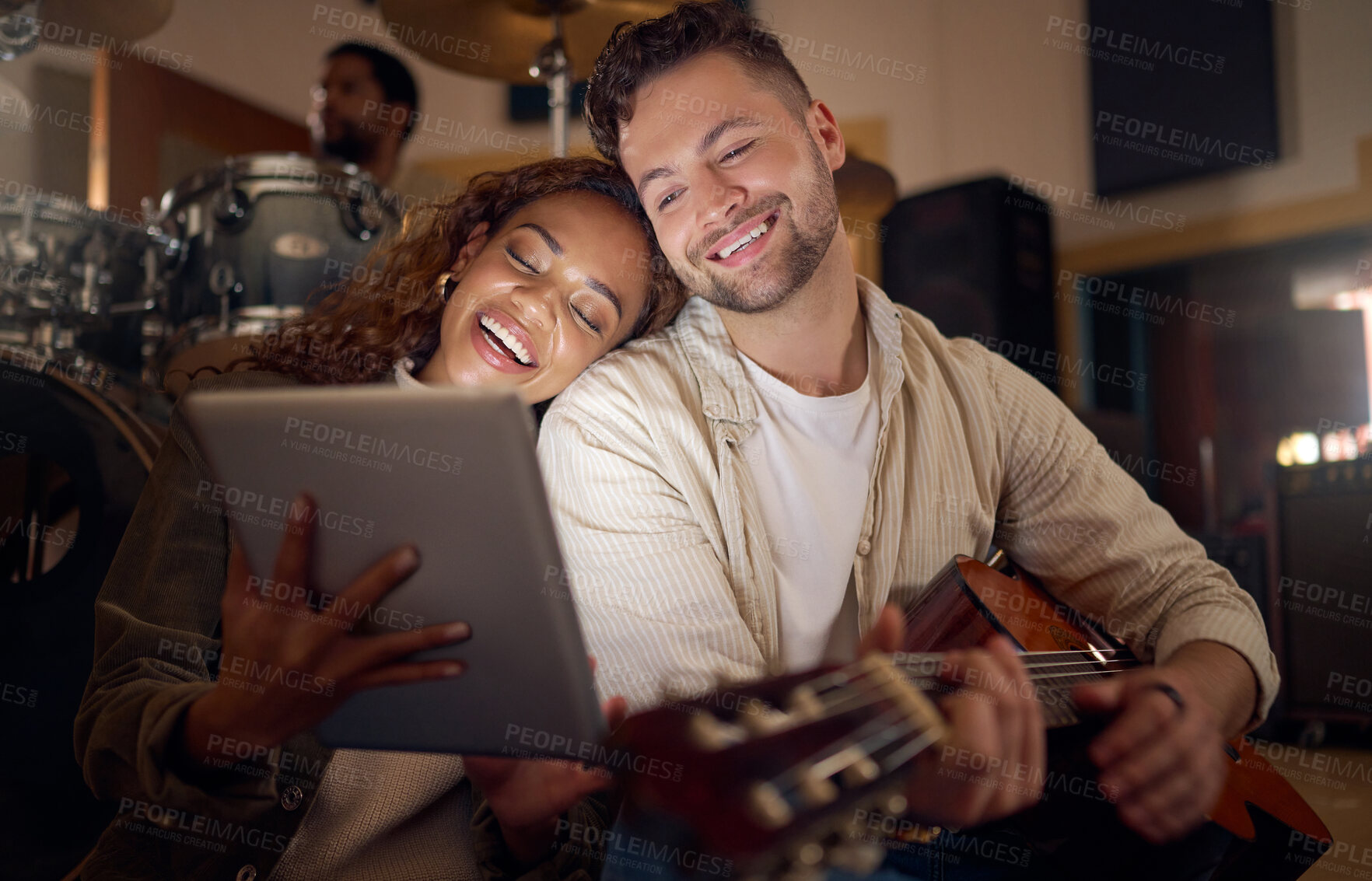 Buy stock photo Guitar, music and couple with digital tablet for online lyrics or strumming notes in recording studio. Happy, smile and young man and woman with mobile device and acoustic string instrument at night.