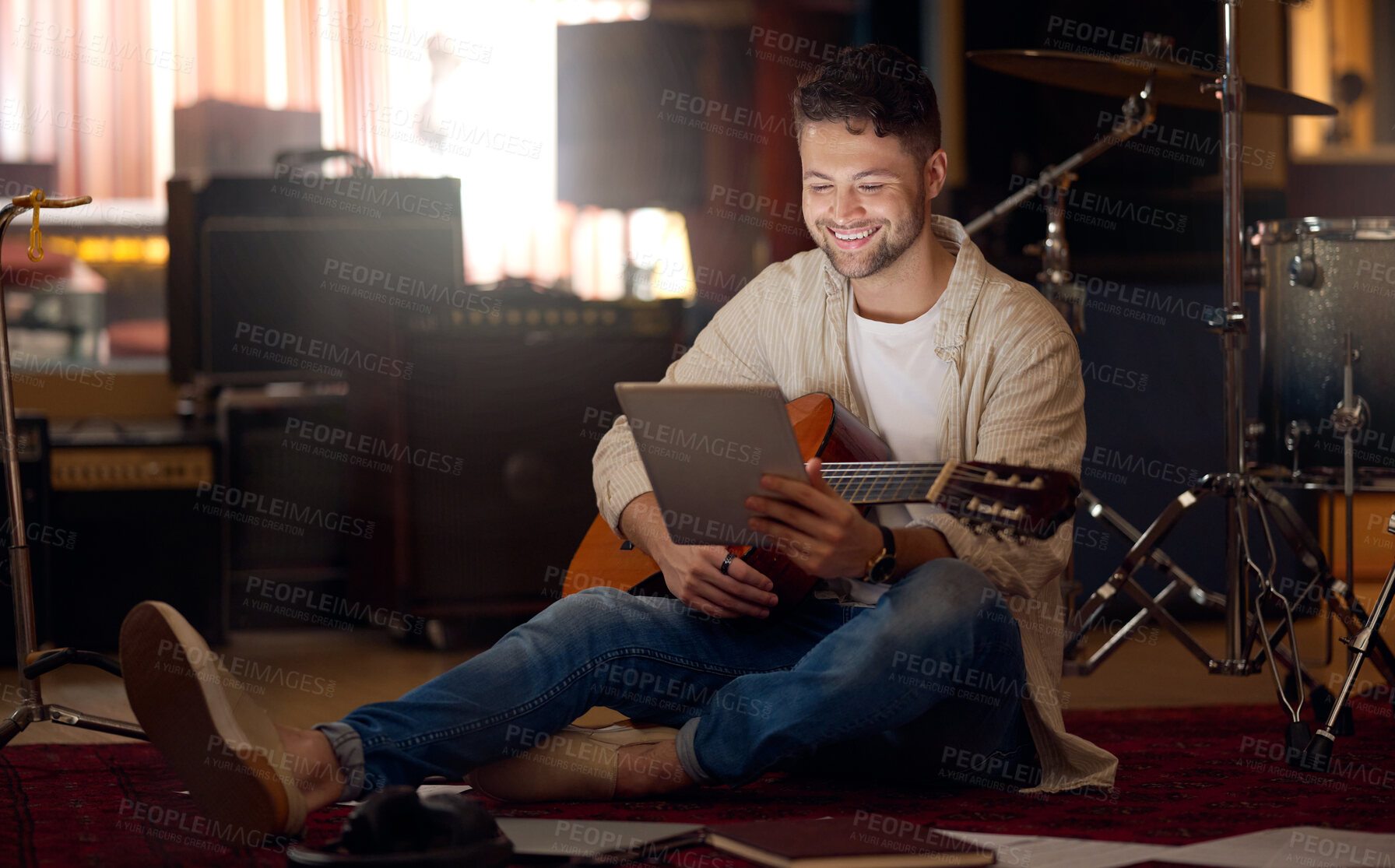 Buy stock photo Digital tablet, guitar and man in a recording studio for music production or acoustic performance. Musician, artist and happy male guitarist on a mobile device with a musical string instrument.