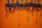 Audio, music and headphones hanging on a wall for a dj, podcast or radio production in the studio. Sound, electronics and equipment for streaming songs, listening to a track or musical accessory