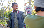 High five, gardening and people in a garden happy and celebrating plant growth for sustainability in the environment. Volunteer, black man and team excited for planting as teamwork in a park