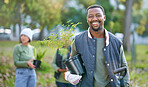 Agriculture, portrait and black man with a plant in nature after doing sustainable gardening in a park. Happy, smile and eco friendly African male gardener standing with greenery on an outdoor field.