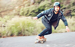 Sports, skateboard and man skating on road for fitness, exercise or wellness. Training, freedom and portrait of male skater moving with fast speed, skateboarding or riding outdoors for action workout