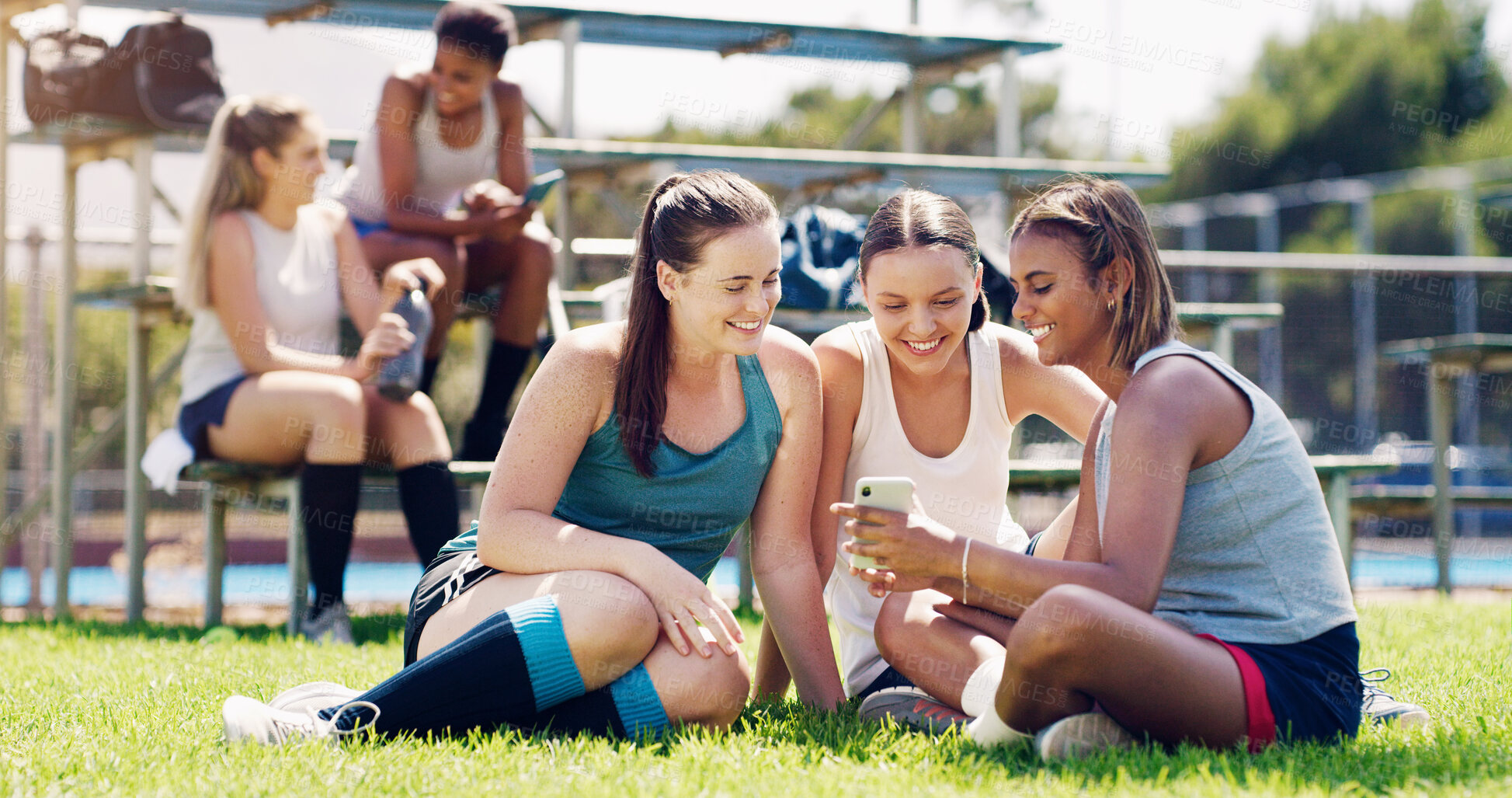 Buy stock photo Sports, women and group outdoor, smartphone and connection with girls on field, chatting and relax. Fitness, female athletes smile and young ladies with cellphone, summer and on break after training