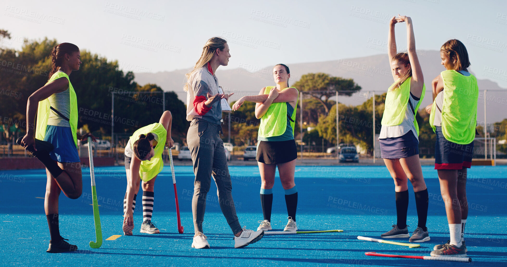 Buy stock photo Hockey, women team with coach and sport outdoor, coaching and game strategy, training and fitness on turf. Athlete stretching, start practice and wellness with match plan, motivation and support