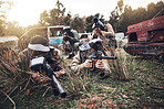 Paintball, camouflage and team playing a match for fun, fitness and extreme sports with guns. Army, weapons and group of military people practicing or training for a game on an outdoor battlefield.