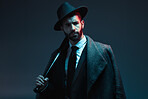 Fashion, criminal and face of man with bat for vintage, retro and Victorian gangster on dark background. Crime aesthetic, thinking and male model with luxury, designer suit and threatening attitude