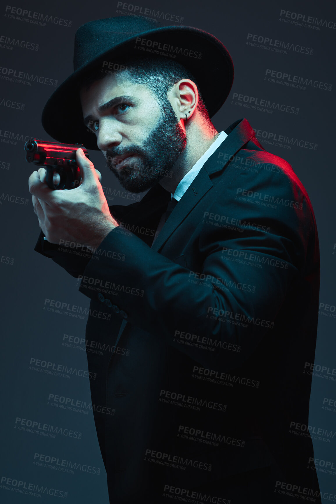 Buy stock photo Gangster, suit and shooting gun on dark studio background in secret spy, isolated mafia leadership and crime lord security. Model, man and hitman aiming weapon in formal or fashion clothes aesthetic