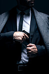 Bodyguard, hands or gun in suit jacket on studio background in dark secret spy or isolated mafia leadership. Gangster, man or criminal hiding weapon in formal, crime lord or fashion clothes aesthetic