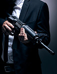 Gangster, hands or holding gun on studio background in dark secret spy, isolated mafia leadership or crime lord security. Model, man or hitman weapon in suit, fashion clothes or bodyguard aesthetic