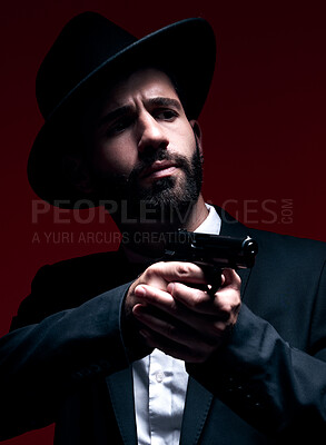 Buy stock photo Assassin, suit or shooting weapon on studio background in dark secret spy, isolated mafia leadership or crime security. Model, gangster or hitman gun in aim, formal style or fashion clothes aesthetic