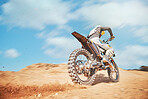 Back of motorbike, offroad sports and speed on blue sky, desert sand or trail. Driver, cycling and power on dirt track, hill and motorcycle performance competition on adventure course for fast action