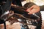 Hands, mechanic and motorbike chain in repairs working on springs or timing for safety or mechanical parts. Hand of engineer fixing bike, transport or transmission on automobile or gears in workshop