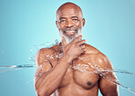Grooming, hygiene and portrait of black man with a water splash isolated on a blue background. Shower, smile and elderly African model with a beard for cleaning, body care and wellness on a backdrop