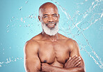 Senior person, water splash and smile portrait of a black man in studio shower for skincare. Spa, blue background and isolated elderly person with happiness for body cleaning and morning dermatology