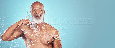Buy stock photo Water splash, dental and black man with toothbrush, mockup and smile on face isolated on blue background space. Teeth, toothpaste and product placement, happy senior in studio portrait cleaning mouth