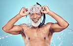 Snorkel, water splash and skincare of black man in studio isolated on blue background. Wellness, cleaning or face portrait of senior male model with scuba mask, bathing or washing for healthy hygiene