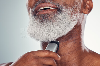 Buy stock photo Grooming, skincare and man shaving beard on face isolated on a grey studio background. Cleaning, smile and African senior model with a tool for facial hair removal, hygiene and routine on a backdrop