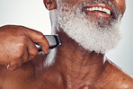 Hand, beard and shaving with an electric razor with a mature black man in studio on a gray background. Face, grooming and hygiene with a mature male in the bathroom to shave for hair removal
