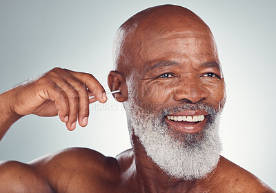 Buy stock photo Cleaning, ear and black man with earbuds, smile on face and body care grooming isolated on grey background. Morning routine, health and happy senior male in mockup, clean ears and wellness in studio.