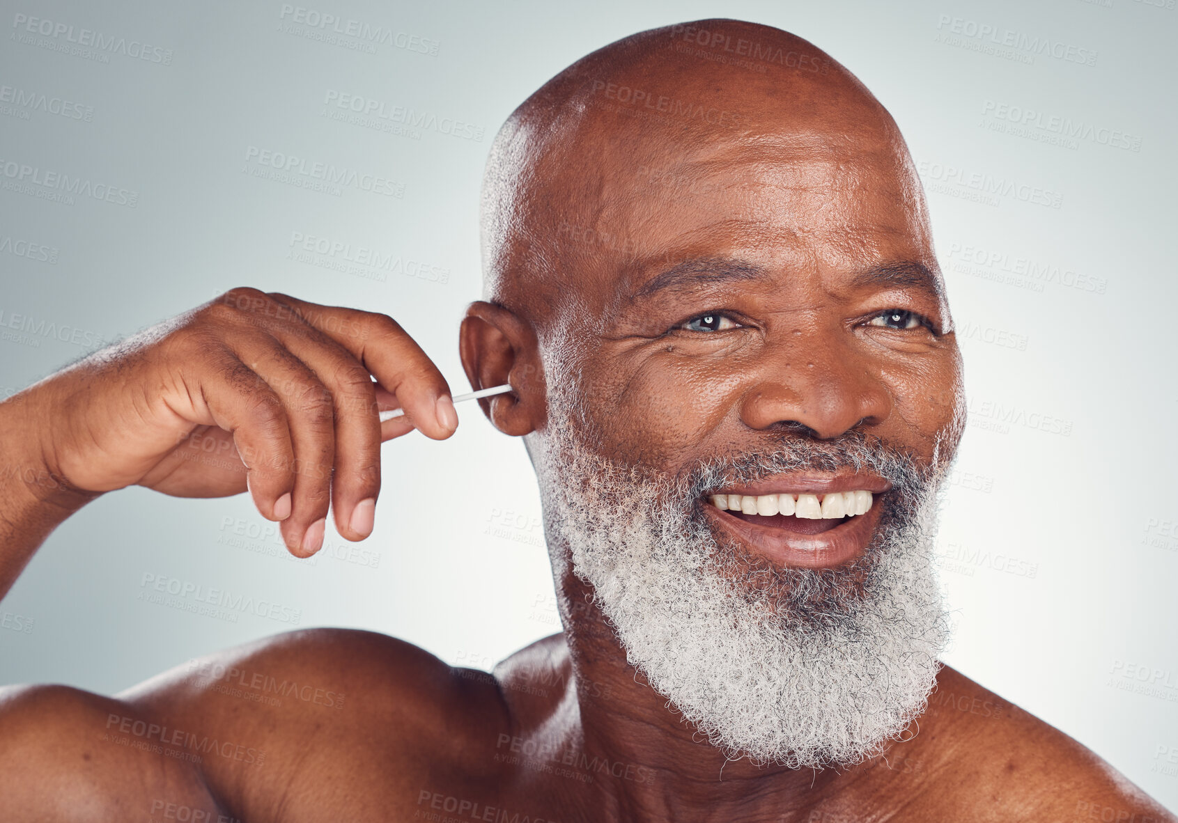Buy stock photo Cleaning, ear and black man with earbuds, smile on face and body care grooming isolated on grey background. Morning routine, health and happy senior male in mockup, clean ears and wellness in studio.