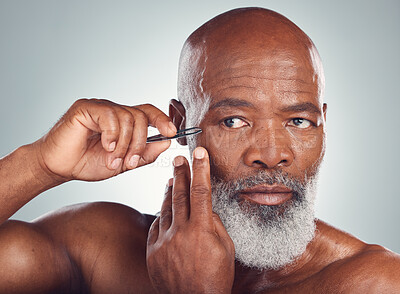 Buy stock photo Grooming, skincare and black man with a tweezers for hair removal isolated on a studio background. Cleaning, beauty and face of an African senior model with a tool for facial care on a grey backdrop